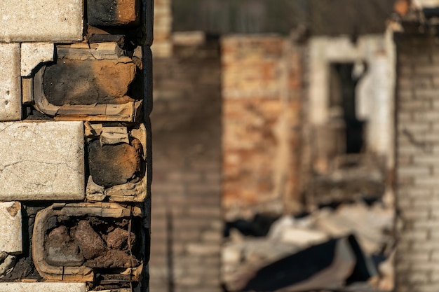 Разрушенный после пожара деревянный частный дом Последствия лесного пожара в деревне Обугленные стены деревянного дома крупным планом