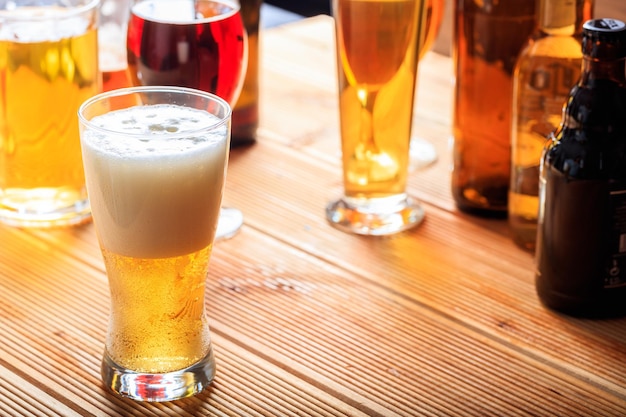 A wooden pub counter focus on a full frosty glass of beer