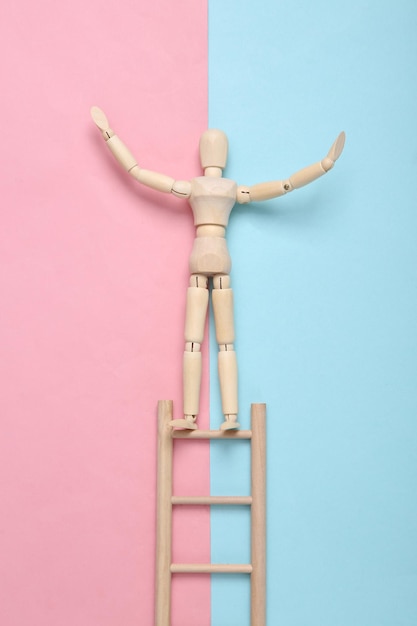 Wooden puppet climbs up the stairs on a bluepink pastel background Career growth concept