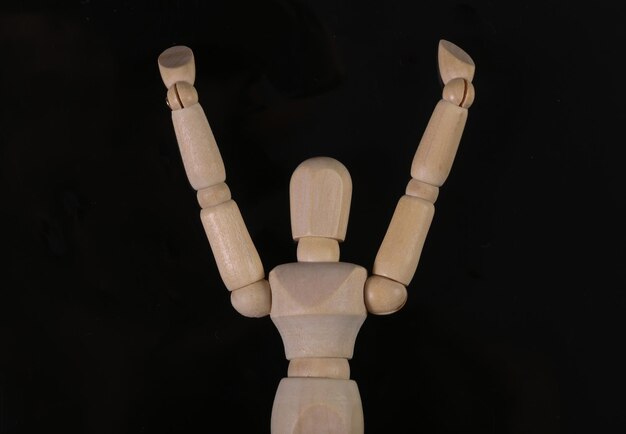 Wooden puppet mannequin isolated on black background