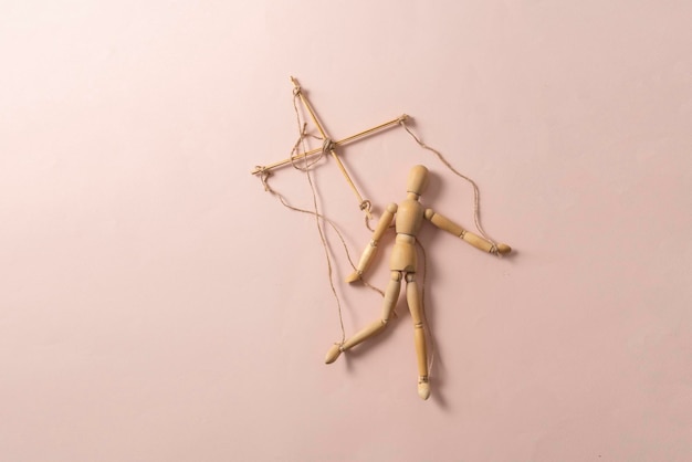 A wooden puppet marionette doll with threads isolated flat lay