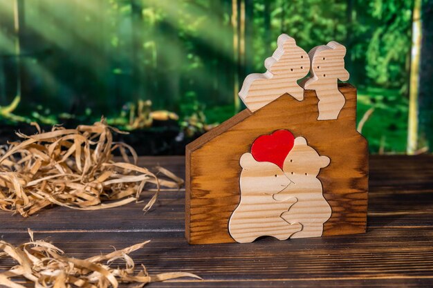 Wooden puzzle in the form of a family of handmade bears on the background of the forest