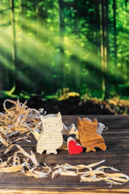 Wooden puzzle in the form of a family of handmade owls on the background of the forest