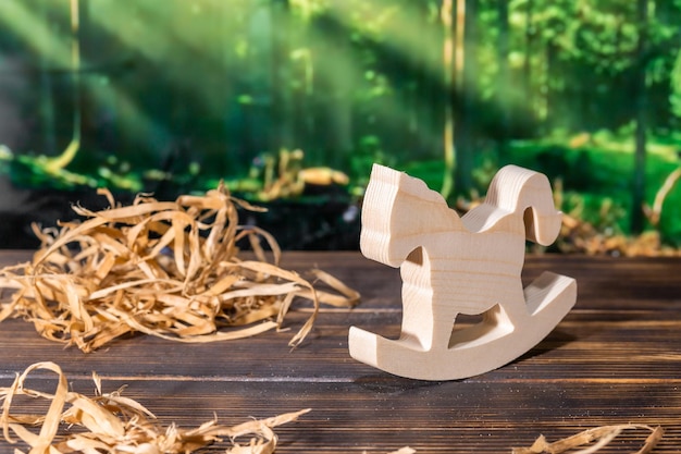 Wooden puzzle in the form of a handmade horse on the background of the forest