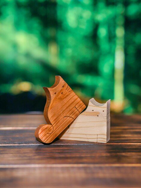 Wooden puzzle in the form of two handmade cats in love on the background of the forest