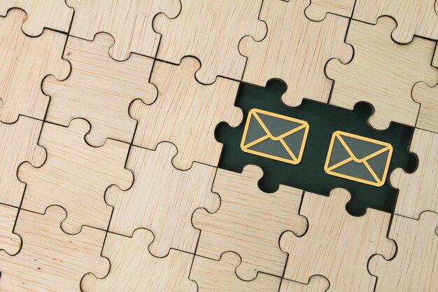 wooden puzzle with unread email icons depicts alert for unread unopened message Envelope concept