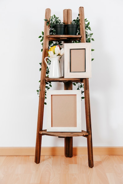 Foto cremagliera in legno con cornici e fiori