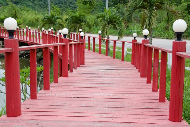 Wooden red bridge in the garden with lamp