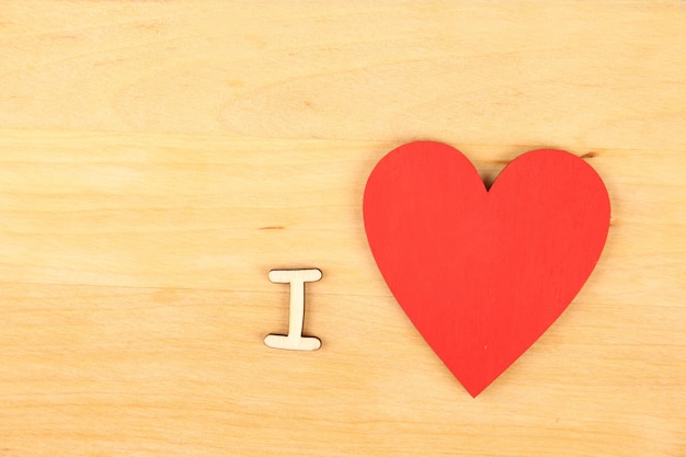 Wooden red heart and the text quotI lovequot on a wooden background