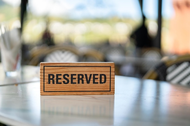 Foto un cartello di legno riservato che è stato posto sul tavolo da pranzo nel ristorante di lusso per la prenotazione del posto