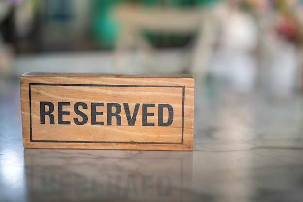座席の予約のために豪華なレストランのダイニングテーブルに置かれた木製の予約サイン