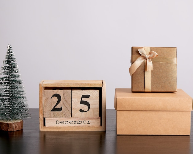 Wooden retro calendar from blocks, Christmas decorative tree and cardboard boxes with gifts