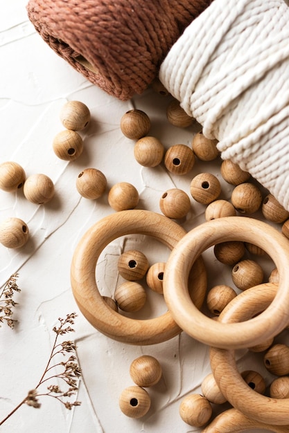 Wooden rings beads and cotton rope for baby teether on white background Natural handmade wood toy for child Ecofriendly children toy Top view flat lay