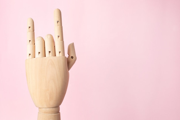 Фото Деревянная рука робота, показывающая рок жест