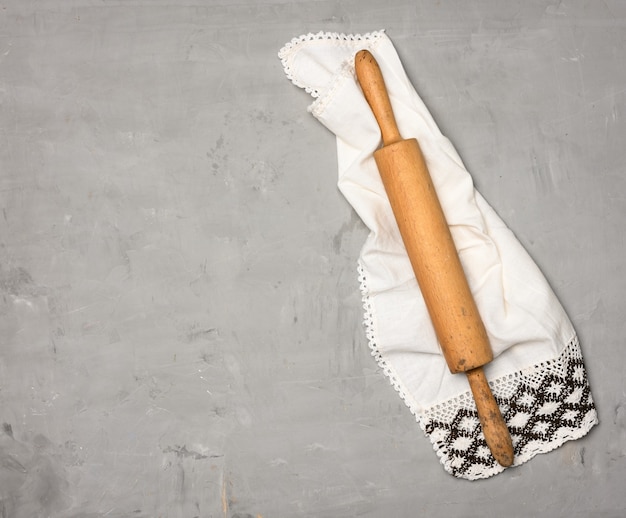 Wooden rolling pin on gray background, top view