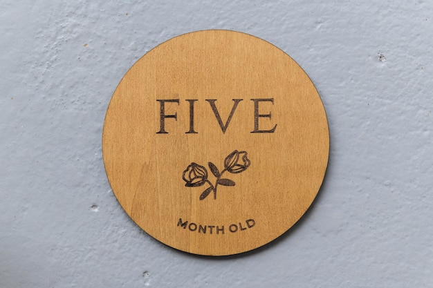 Wooden round board with the inscription five on a gray background