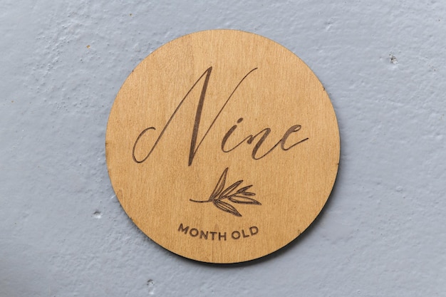 Wooden round board with the inscription nine on a gray background
