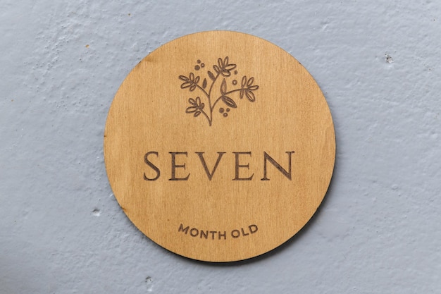 Wooden round board with the inscription seven on a gray background