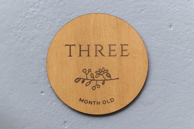 Wooden round board with the inscription three on a gray background