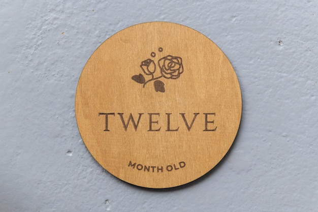 Wooden round board with the inscription twelve on a gray background