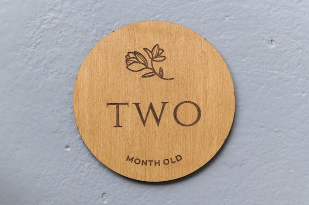 Wooden round board with the inscription two on a gray background