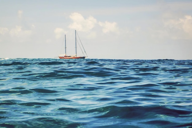 Wooden Sailboat Sailing on the Horizon, Open Blue sea