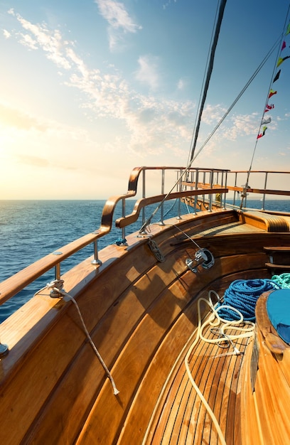 Wooden sailboat in turquiose sea at sunset