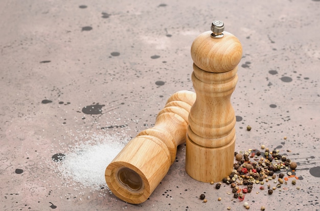 Деревянная солонка и перечница. Приправа соль и перец на столе.