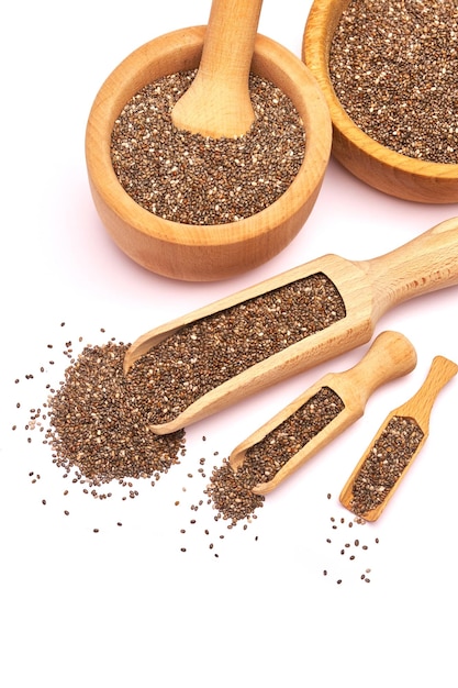 Wooden scoop of organic natural chia seeds closeup isolated on white background