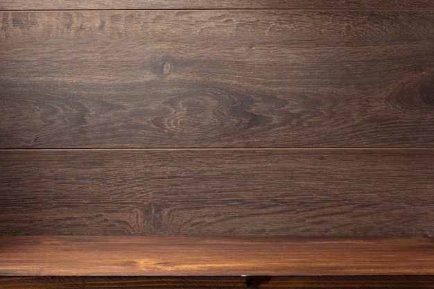 Wooden shelf on brown background