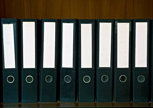 Wooden shelf with document folders and blank label