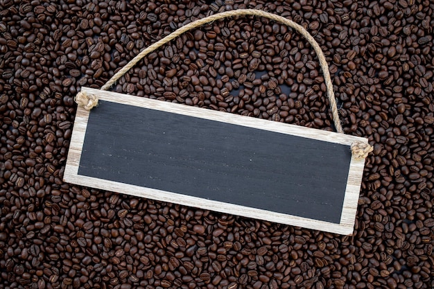 Photo wooden sign hot coffee and beans on wooden table background
