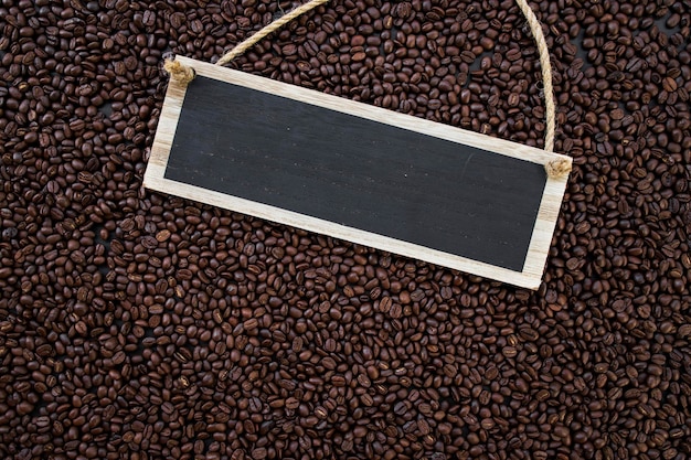 Wooden sign hot coffee and beans on wooden table background