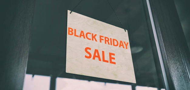 The wooden sign with text Black Friday Sale hanging on the door in the store