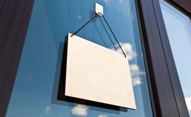 The wooden sign without text hanging on the door in cafe