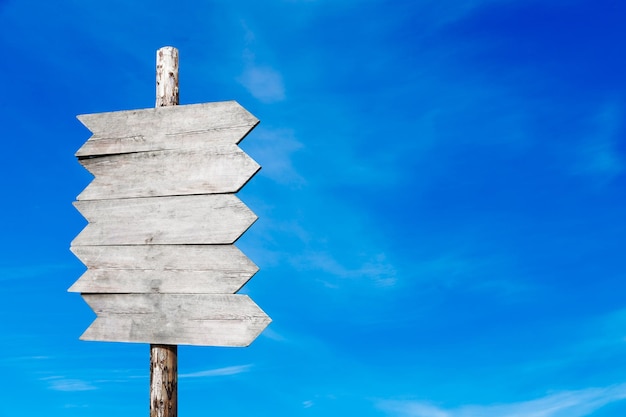 Wooden signpost on a background of blue sky with clouds