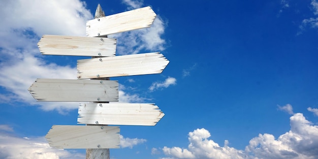 Wooden signpost with six clear arrows