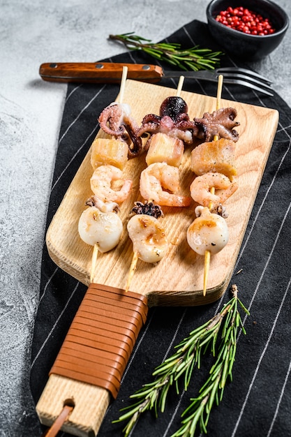 Wooden skewers with grilled seafood, shrimp, octopus, squid and mussels. Top view