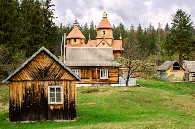 Photo wooden small orthodox church in a mountain village in the carpathians in ukraine.