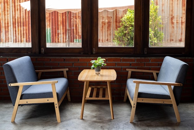 wooden sofa with soft cushions in gray wooden ornaments sits on a wooden table by the window in a coffee shop