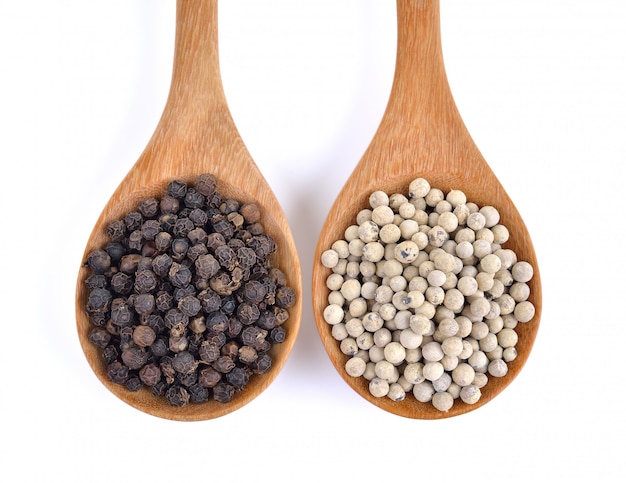Wooden spoon and black peppercorn isolated