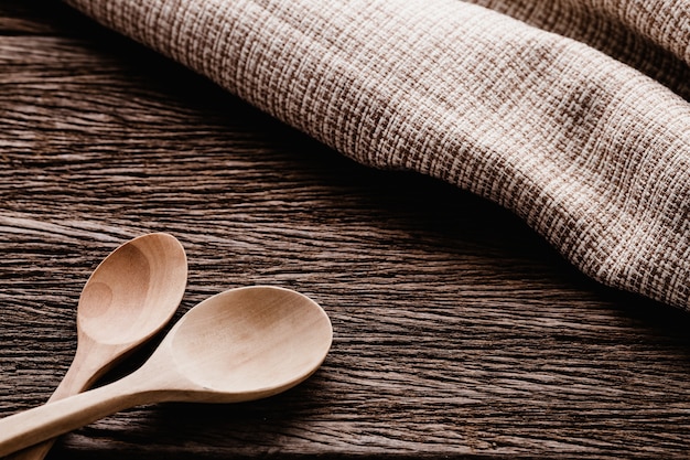 wooden spoon on brown napkin on old wooden texture background