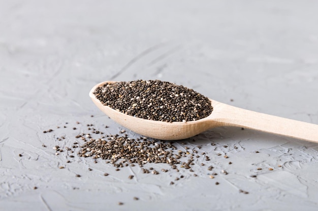 Wooden spoon and chia seeds on colored background top view Healthy Salvia hispanica Healthy superfood