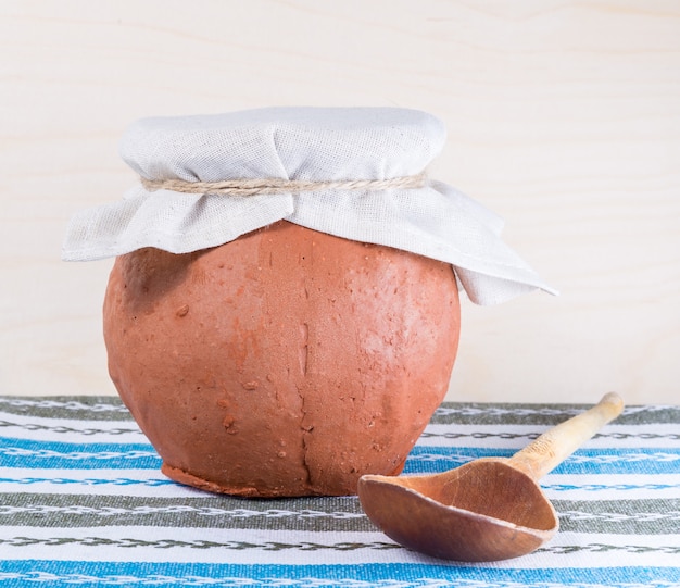 Wooden spoon and clay pot  