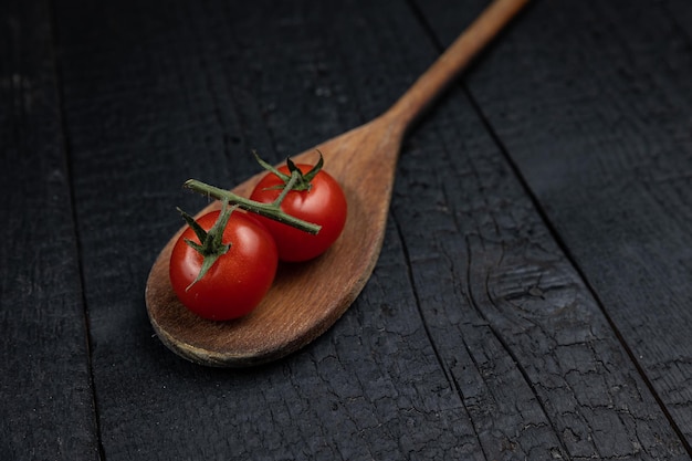 Wooden spoon on a dark background with vegetables