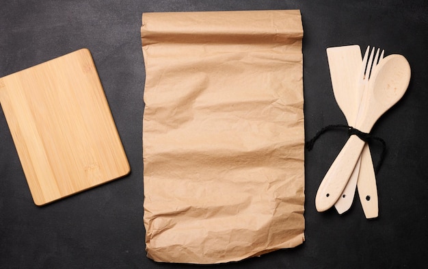 Photo wooden spoon fork and brown sheet of paper