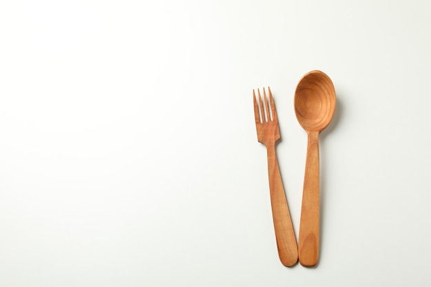 Wooden spoon and knife on white