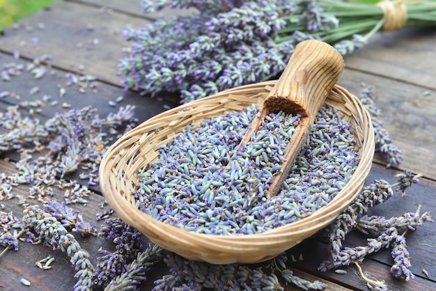 Wooden spoon in a little basket  full of petals of lavender flowers  on a wooden table