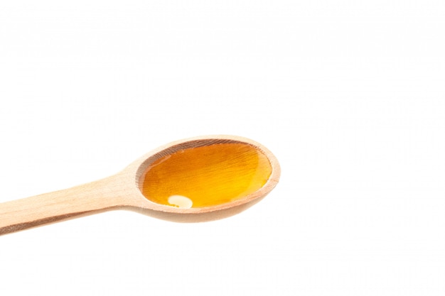 Wooden spoon with honey isolated on white