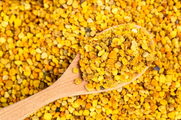 Wooden spoon with natural bee pollen on bee bread